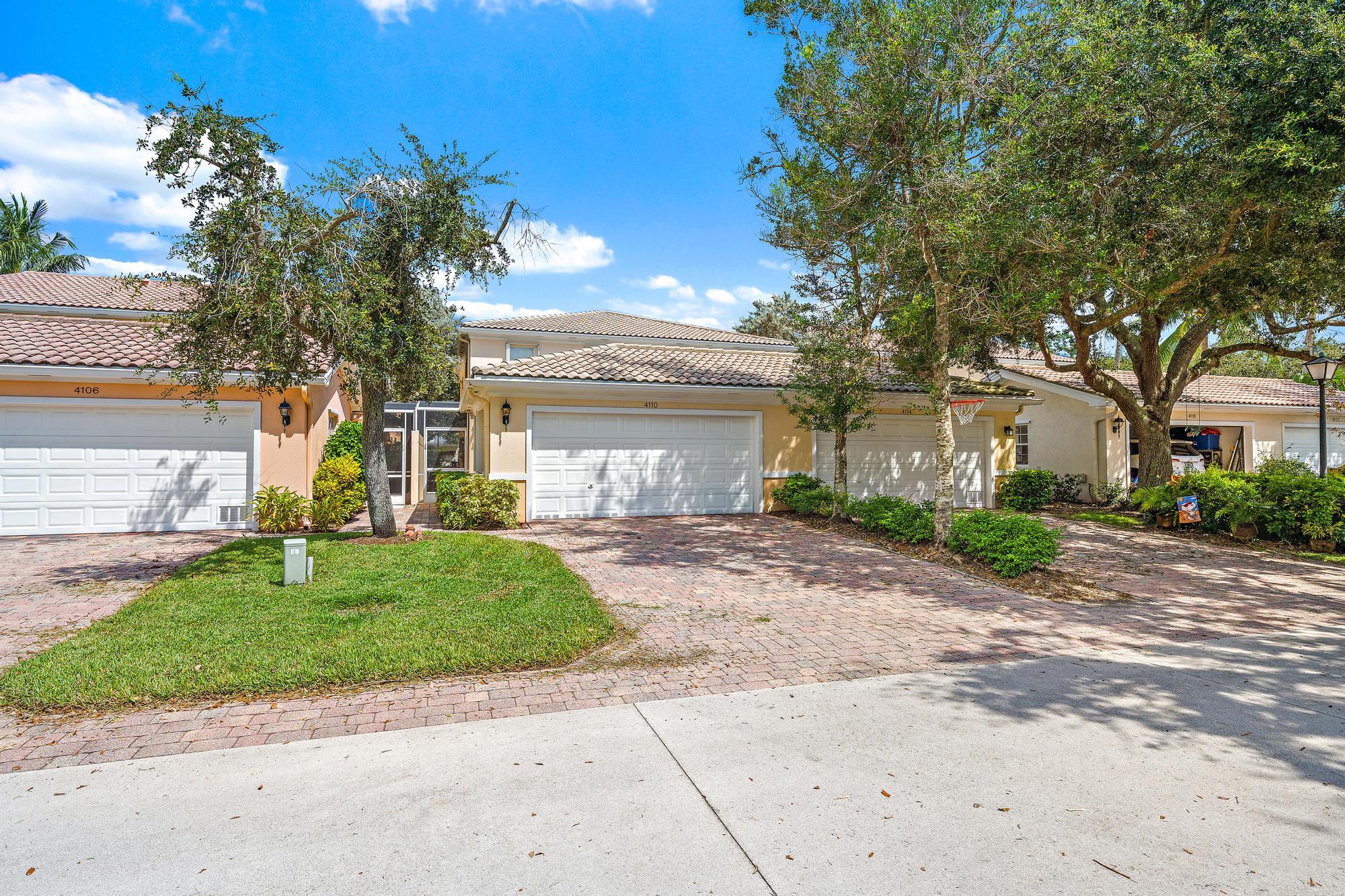 4110 Parkside Drive, a beige home with a tiled roof, white garage door, and brick driveway.