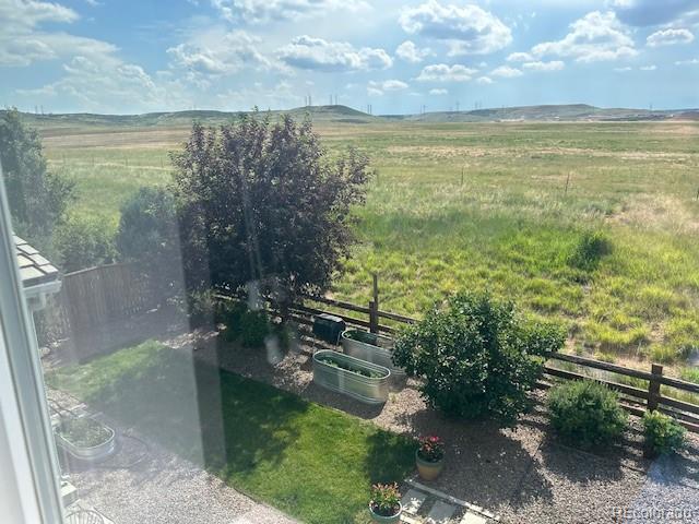 Landscaped backyard overlooking open fields and distant hills.