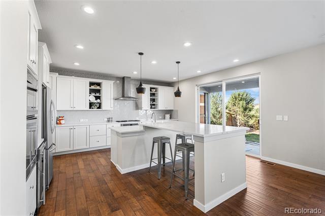 Kitchen with a large white island, stainless steel appliances, and sliding doors to a patio.