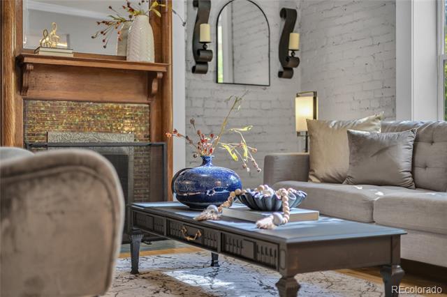 Living room with a blue vase on a coffee table and a wood-mantel fireplace.