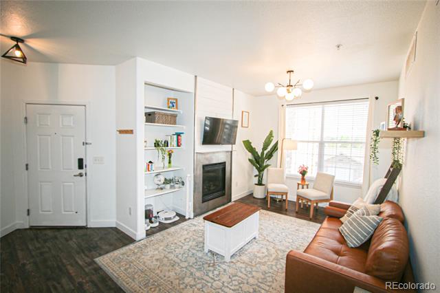 Living room with a leather sofa, built-in shelves, fireplace, and bright windows.