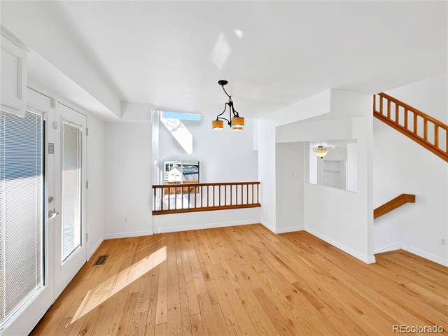 Entryway with wood floors, a glass front door, and open stair railings.