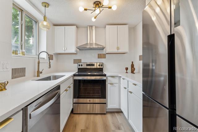 Kitchen with white shaker cabinets, stainless steel appliances, and a sink beneath a window.