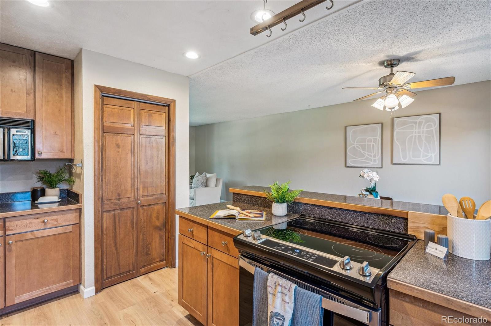 Kitchen with warm wood cabinets, dark granite counters, and a stainless steel range.