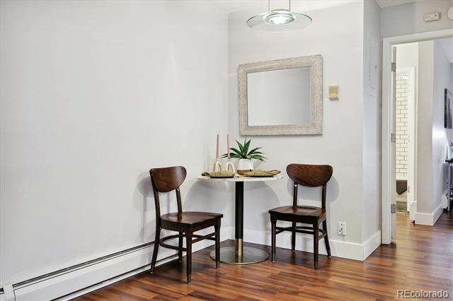 Dining nook with a round table, two wooden chairs, and polished hardwood floors.
