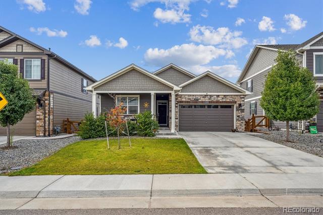Single-story gray home with stone accents, two-car garage, and small front lawn.
