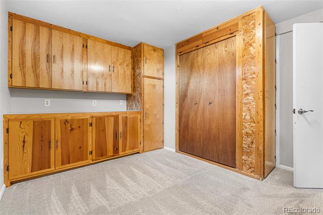 Utility room with built-in honey-colored cabinets and large wood-paneled closet doors.