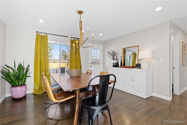 Dining room with a wooden table, yellow curtains, white sideboard, and dark wood floors.