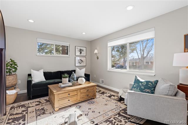 Living room with a black sofa, gray armchair, wooden coffee table, and patterned rug.