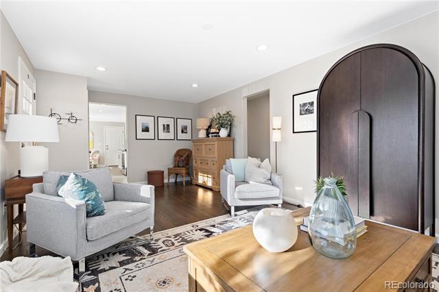 Furnished living room with gray seating, a patterned rug, and a large arched dark-wood doorway.