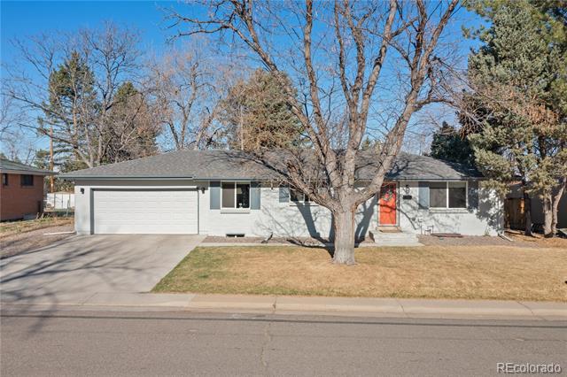 Single-story home with a white garage, red front door, and large leafless tree in the yard.