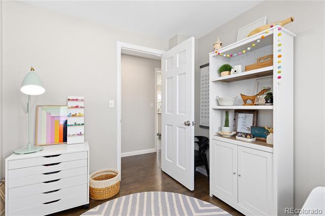 Bright room with white storage drawers, decorated open shelves, and an open door.