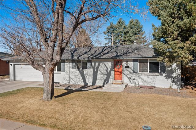 Single-story gray house with an attached garage, red front door, and mature trees.