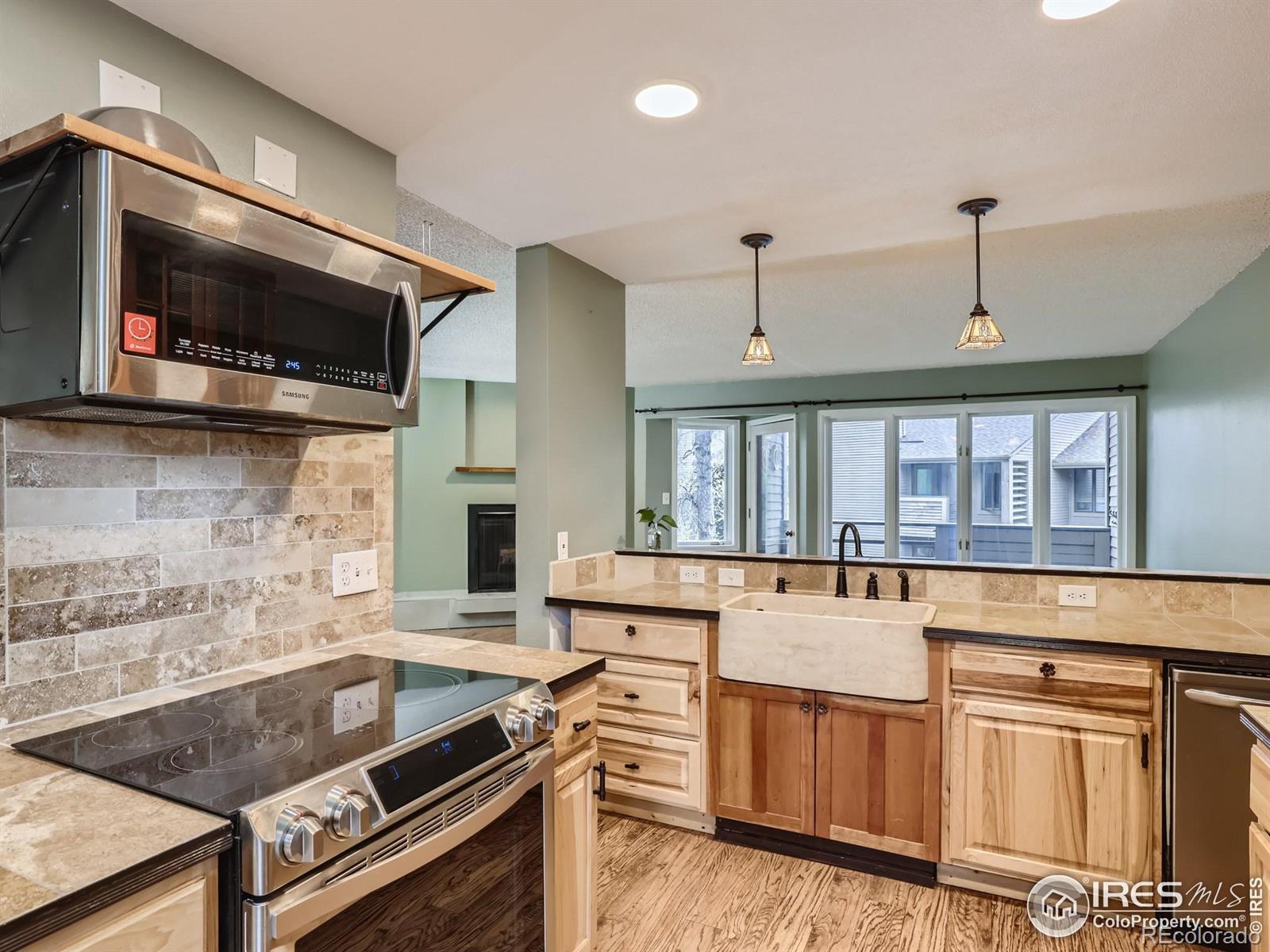 Kitchen with a large farmhouse sink, natural wood cabinetry, and stainless steel appliances.