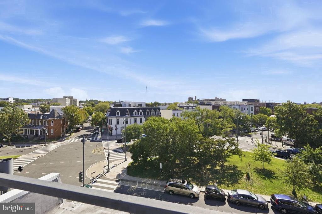 Elevated view of a Washington, DC intersection and neighborhood, with leafy trees and a small green space.