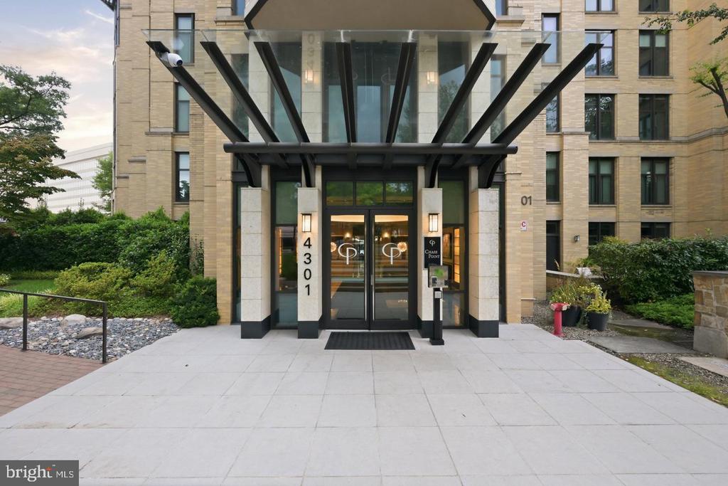 Chase Point condominium entrance with a glass canopy and stone facade.