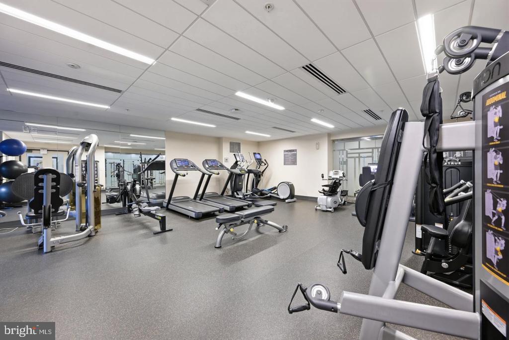 Fitness center with treadmills, weight machines, and mirrored walls.