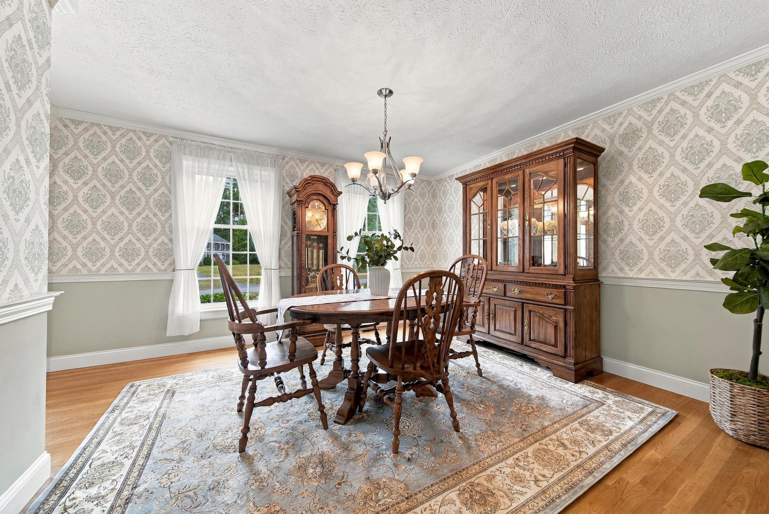 Dining room with a carved wooden table, glass-front china cabinet, and grandfather clock.