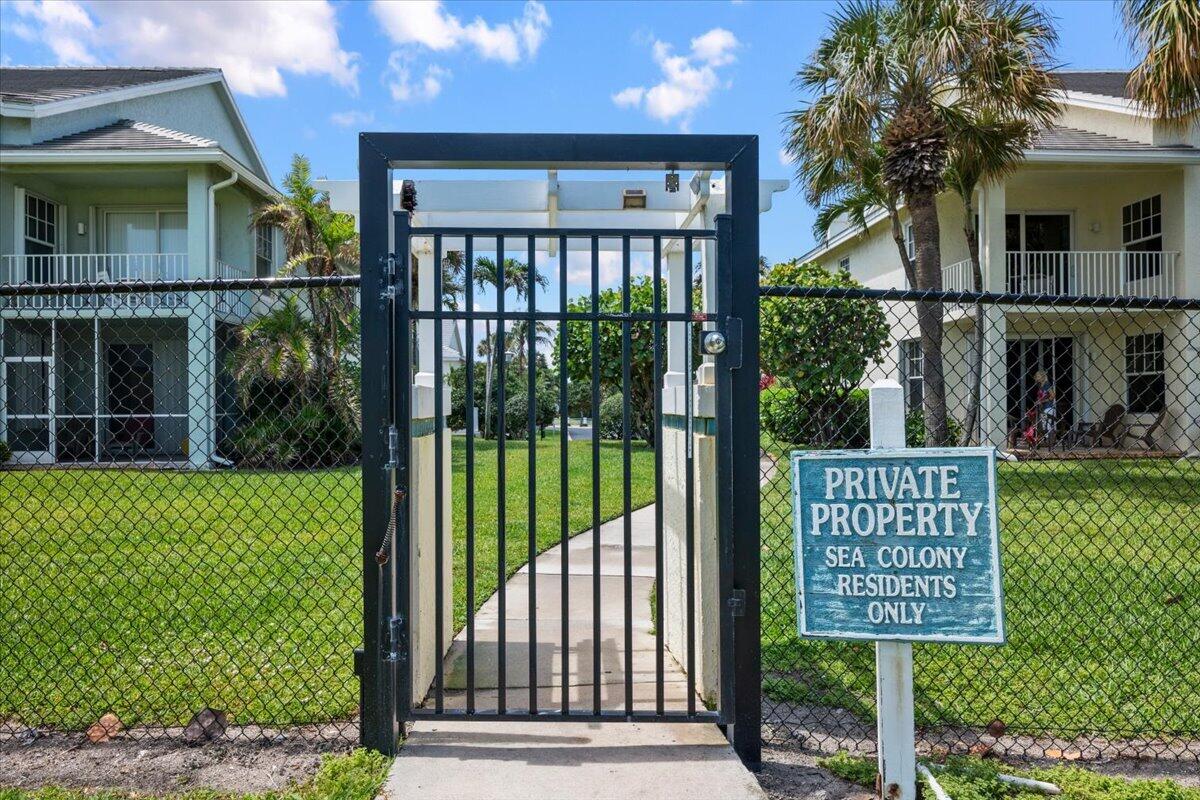 Gated walkway between homes, beside a sign restricting access to Sea Colony residents.