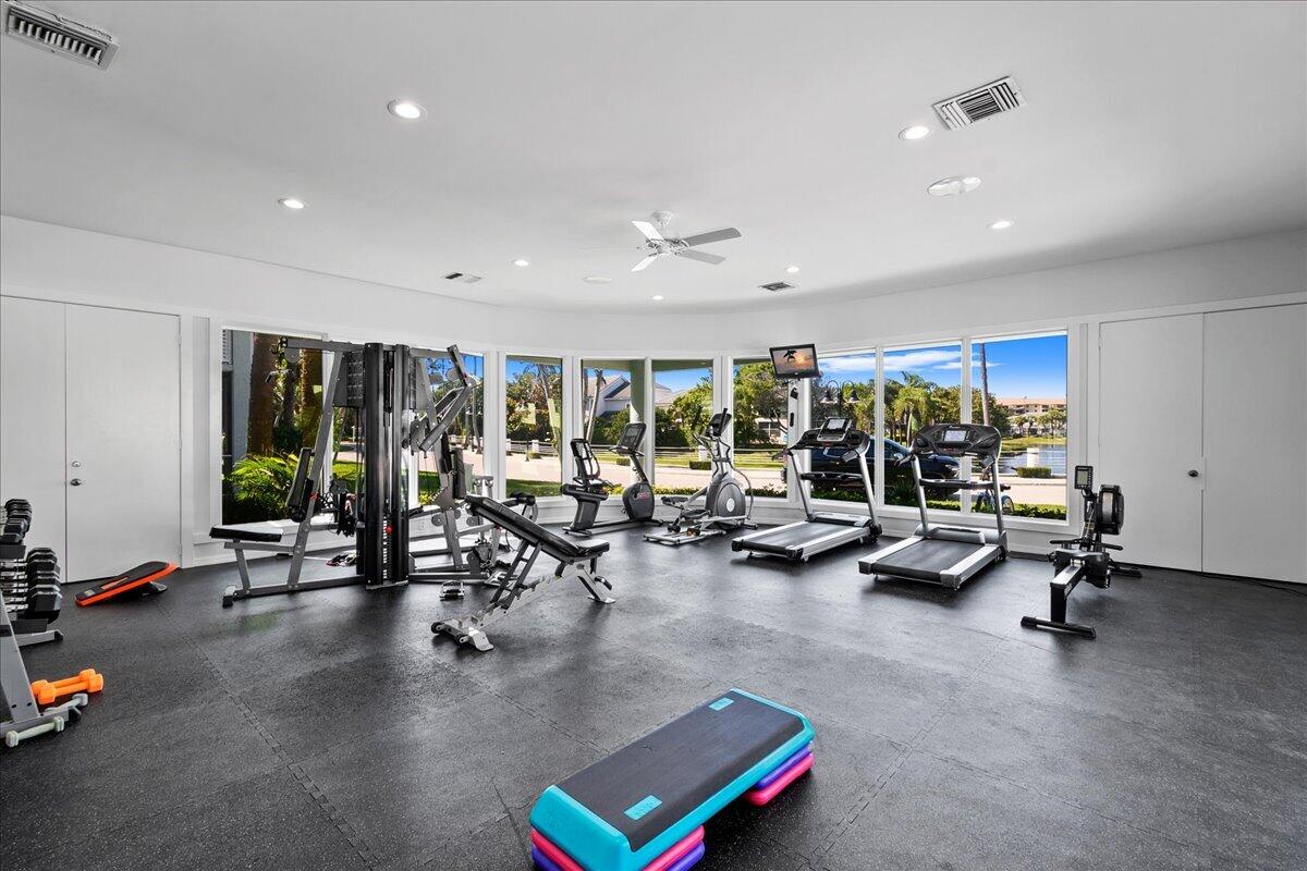 Home gym with exercise equipment and large windows overlooking the water.