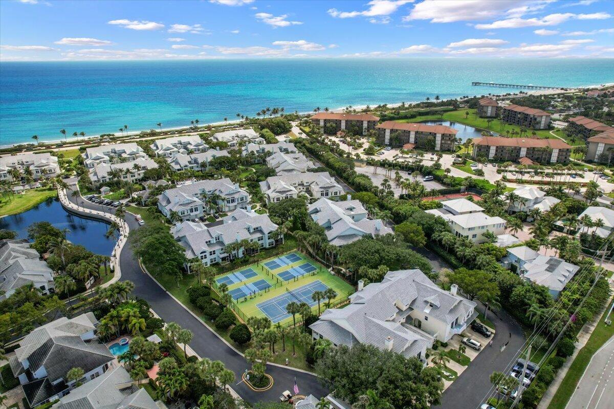 Coastal neighborhood beside the Atlantic Ocean, with tennis courts and homes in the foreground.