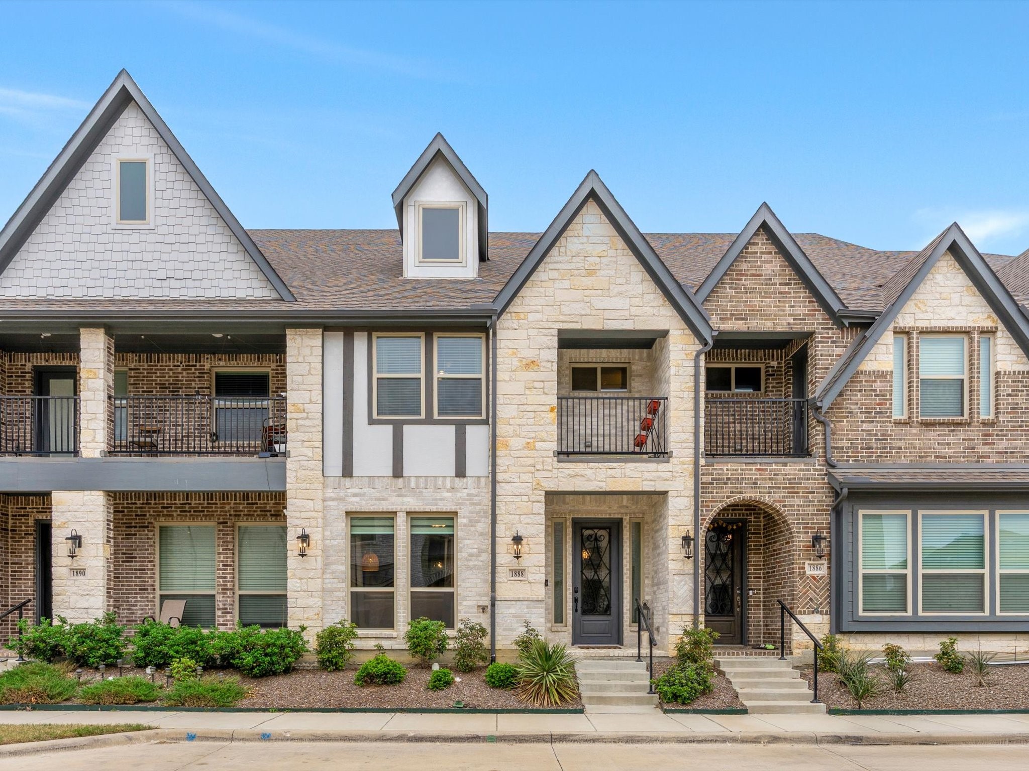Townhouse at 1888 Melinda Lane with a steep gabled roof, stone facade, and upper balcony.