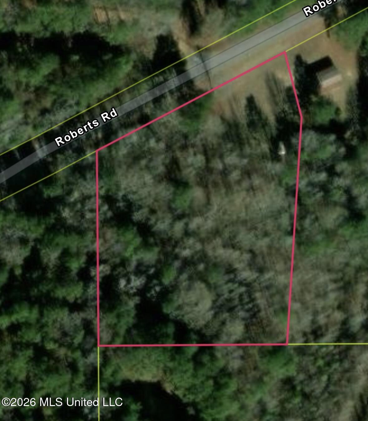 Aerial view of a wooded parcel outlined beside Roberts Road.