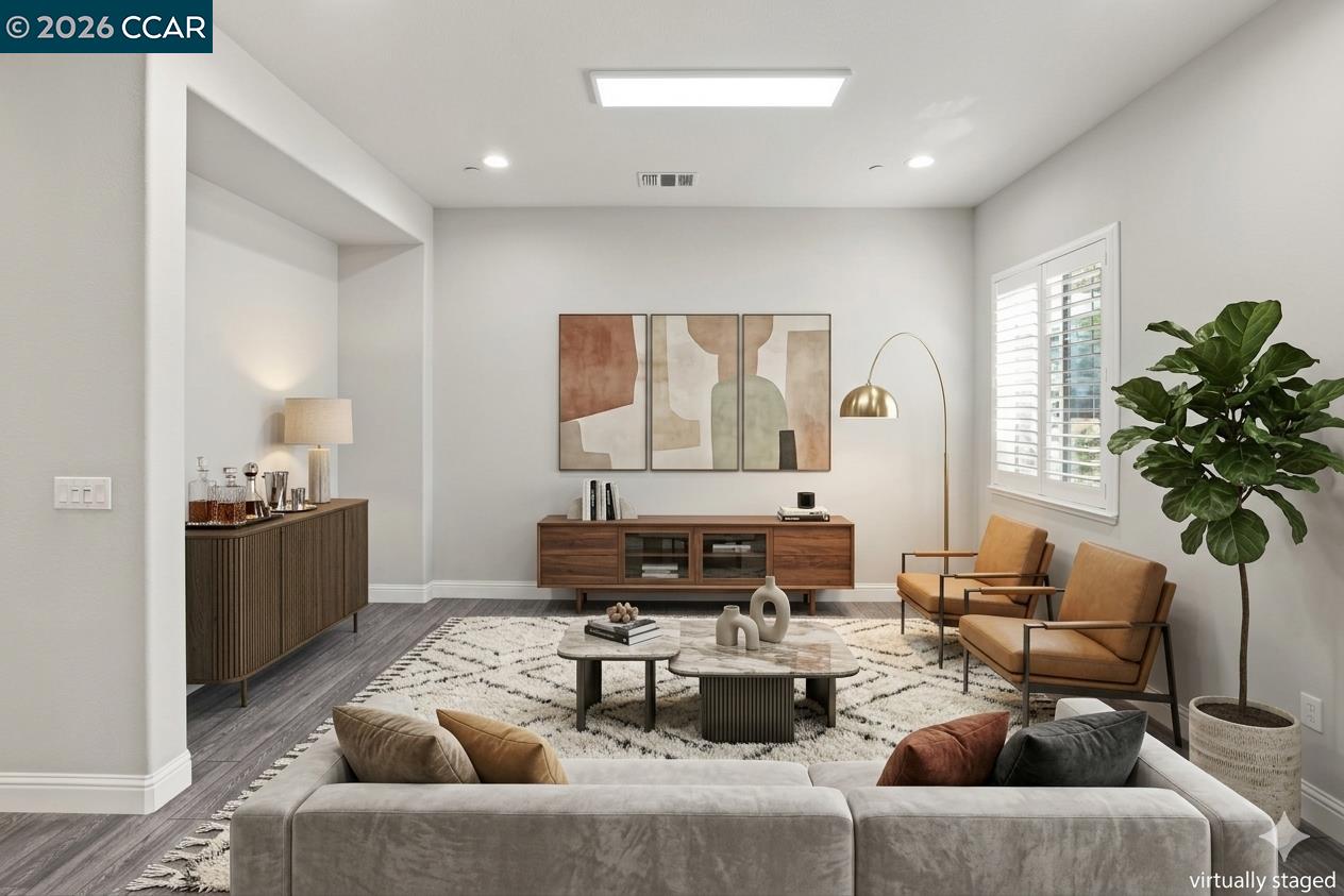 Virtually staged living room with a gray sofa, tan armchairs, and walnut media console.