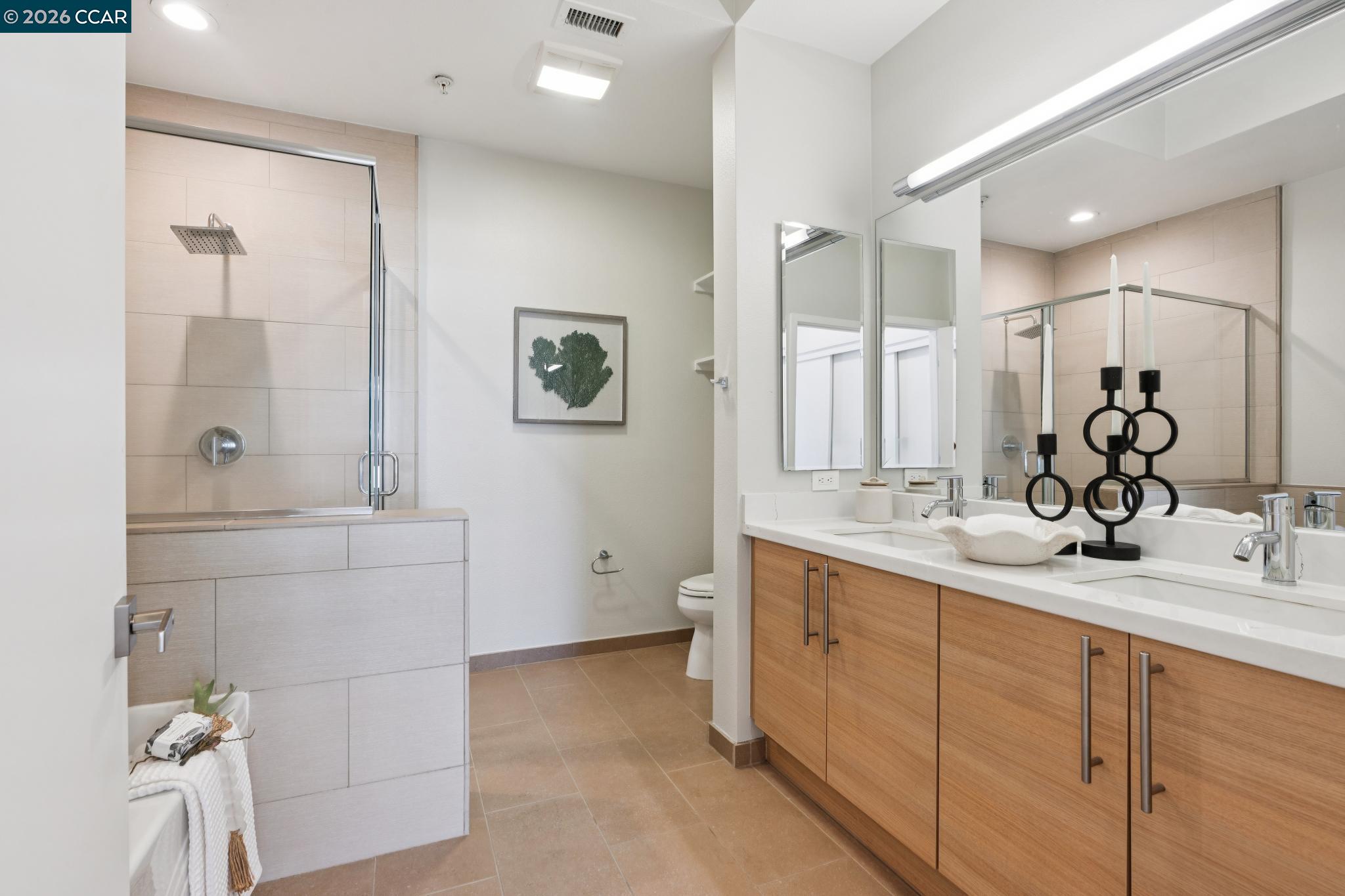 Modern bathroom with a glass shower and double-sink wood vanity.