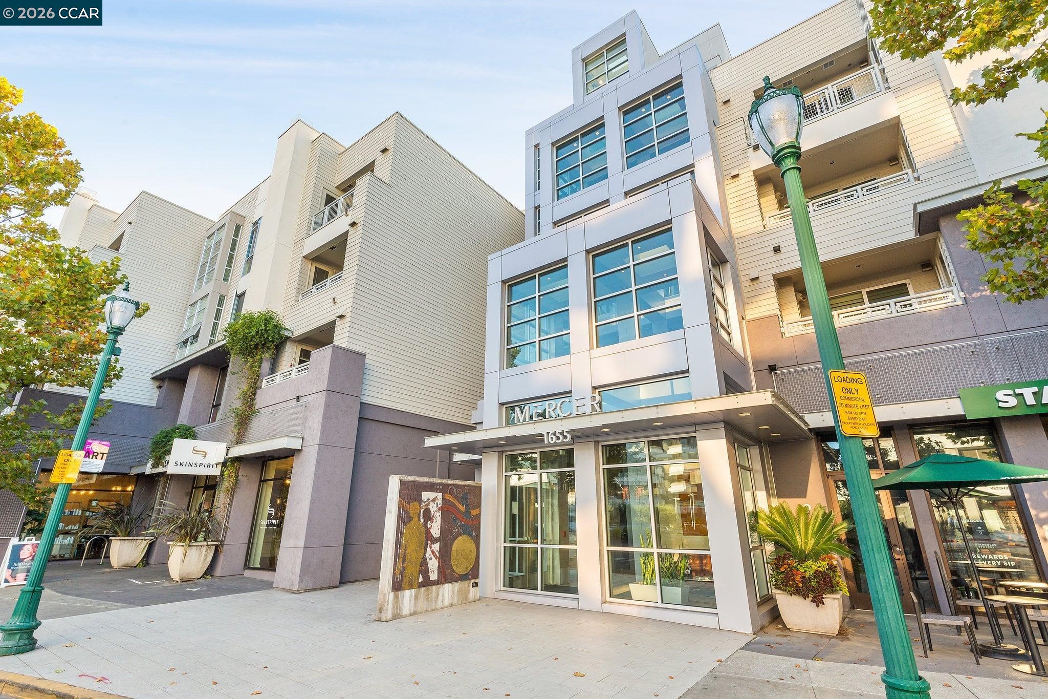 Mercer building entrance at 1655, with glass doors, multistory balconies, and neighboring storefronts.