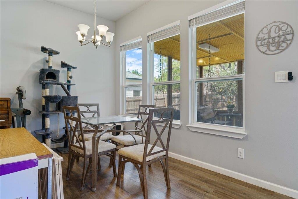 Dining area with a wooden table, large patio-facing windows, and a tall cat tree.