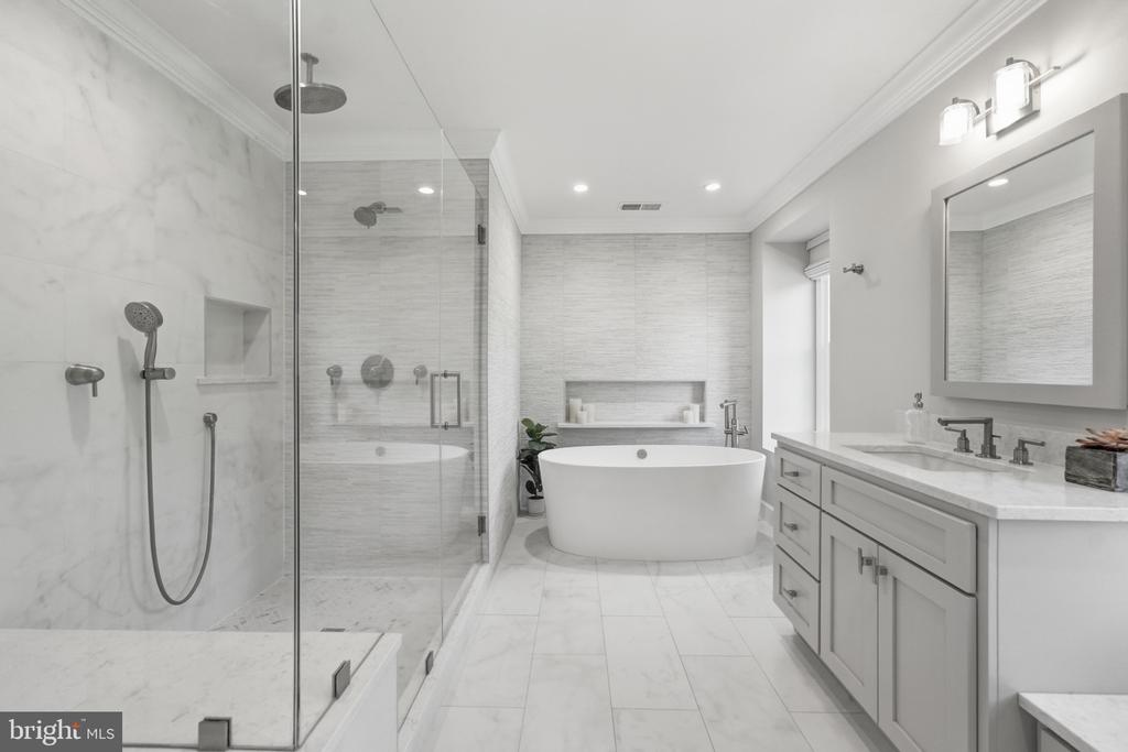 Bathroom with a glass-enclosed rainfall shower, freestanding tub, and long double-sink vanity.