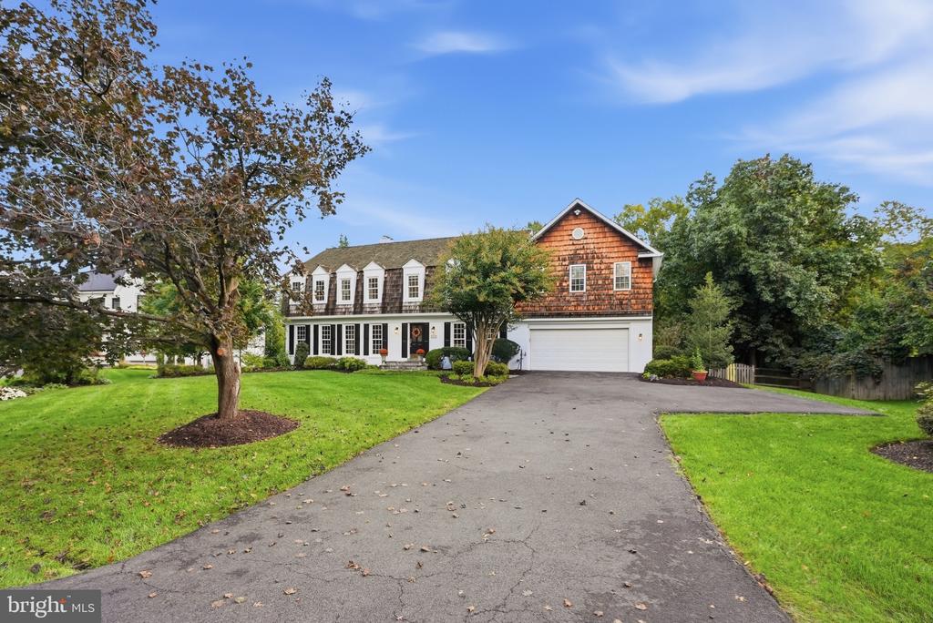 Two-story home with a cedar-shingle gable, attached garage, and broad driveway.