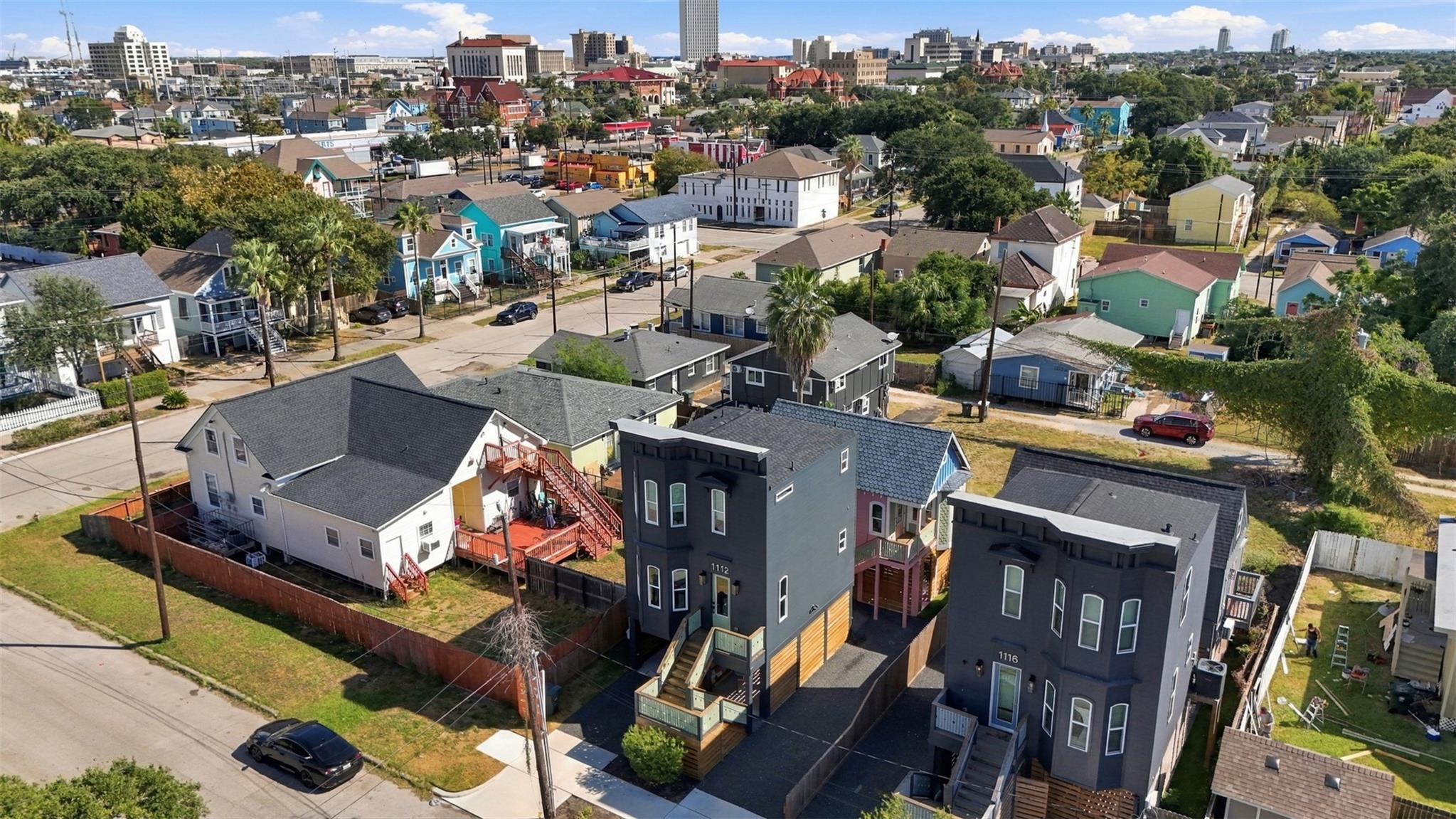 Aerial view of the dark gray home at 1112 30th Street, with Galveston’s neighborhood and skyline beyond.