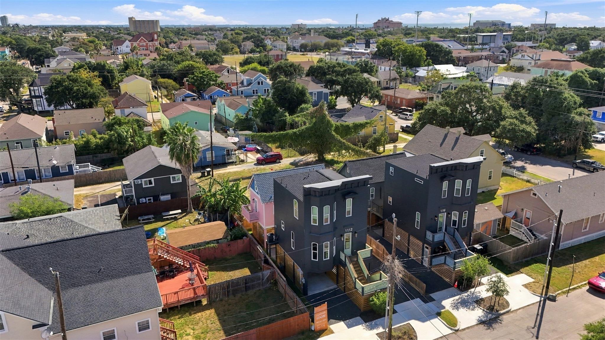 Aerial view of the dark gray multi-story home at 1112 30th Street, with decks and a fenced yard.