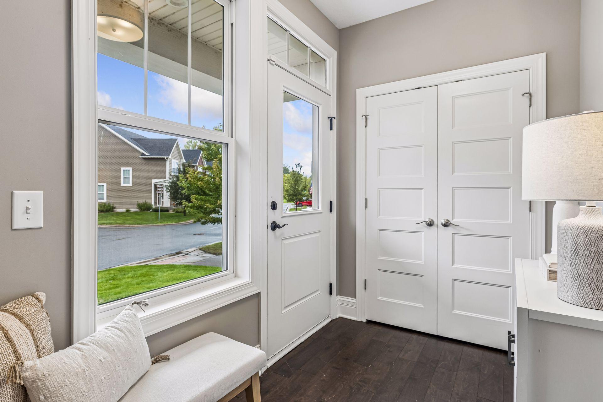 Furnished entry foyer with a large street-facing window and white double closet doors.