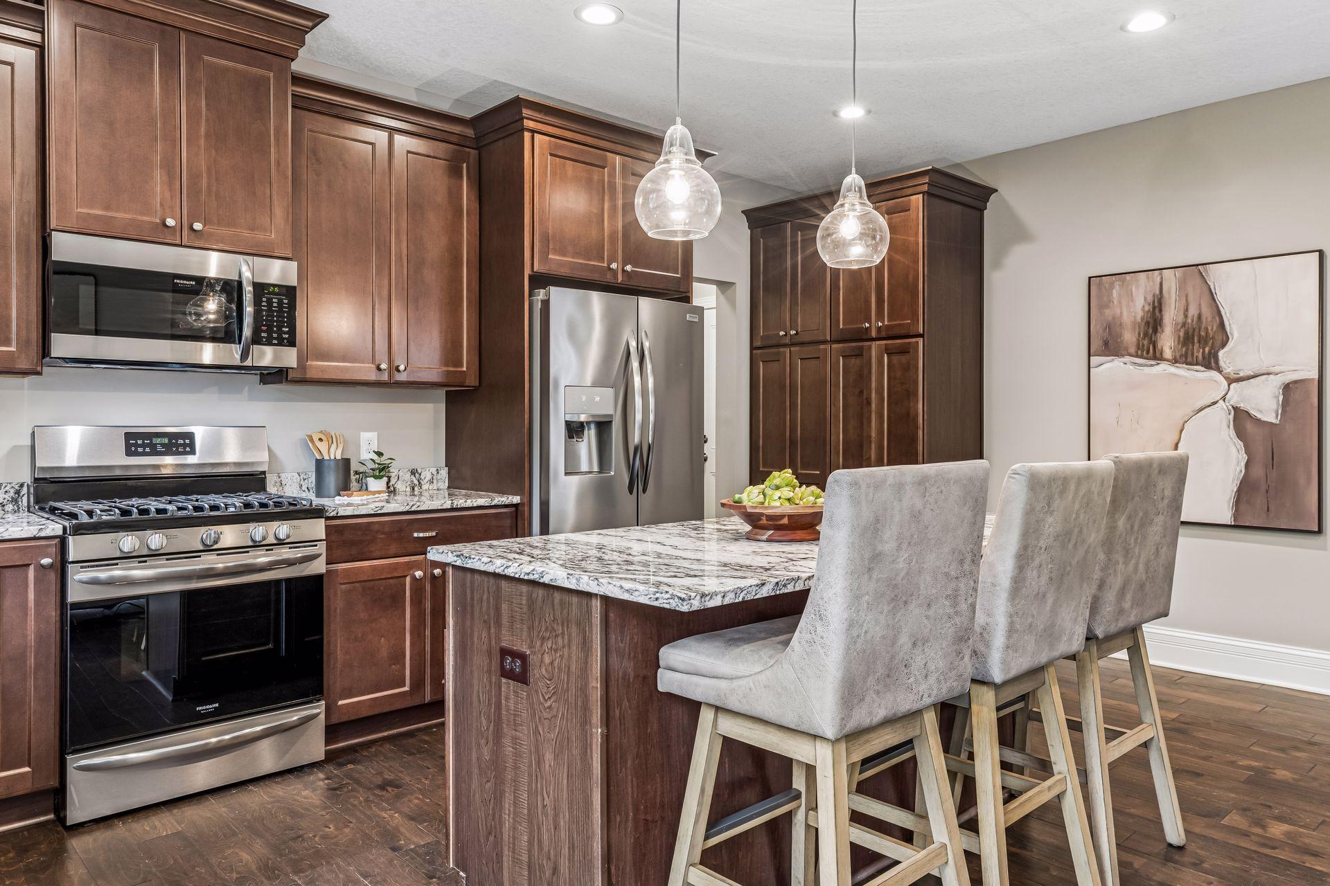 Kitchen with dark wood cabinets, stainless steel appliances, and a marble-patterned island with bar stools.