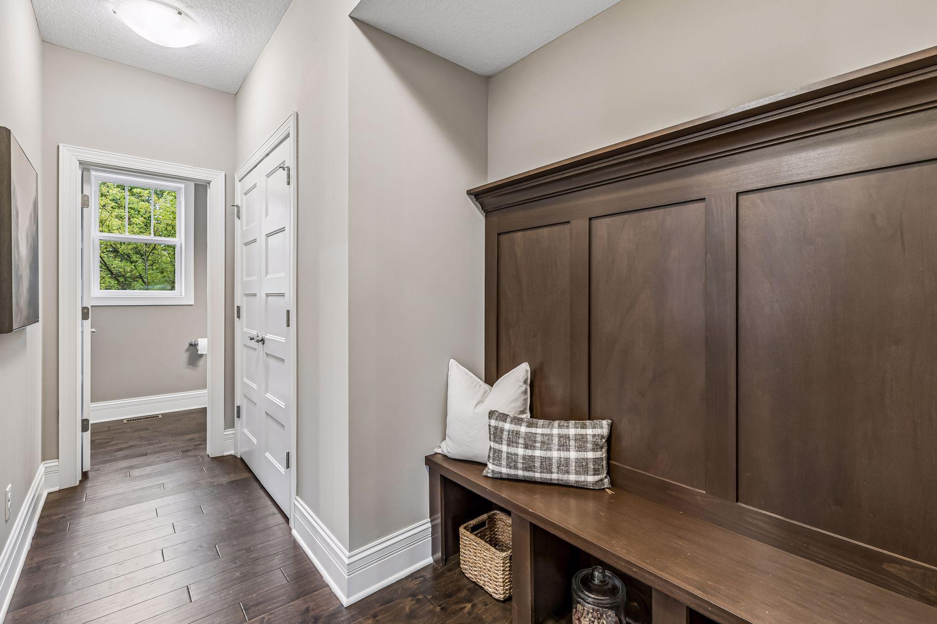 Entry hall with a dark built-in bench, storage cubbies, and a windowed doorway.