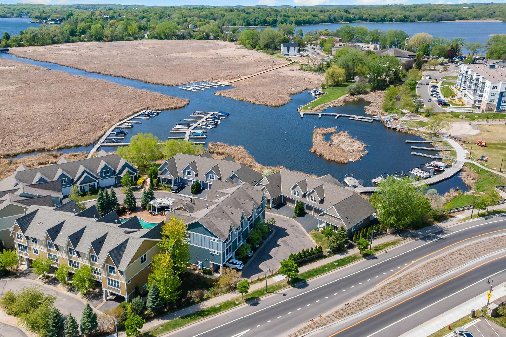 Waterfront homes and marina surrounded by wetlands, with docks and a road in the foreground.