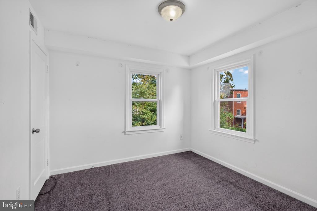 Unfurnished room with gray carpet, white walls, and two windows.