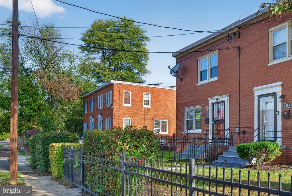 Red-brick rowhouse at 1017 Booker Drive behind a black iron fence, with front steps and shrubs.
