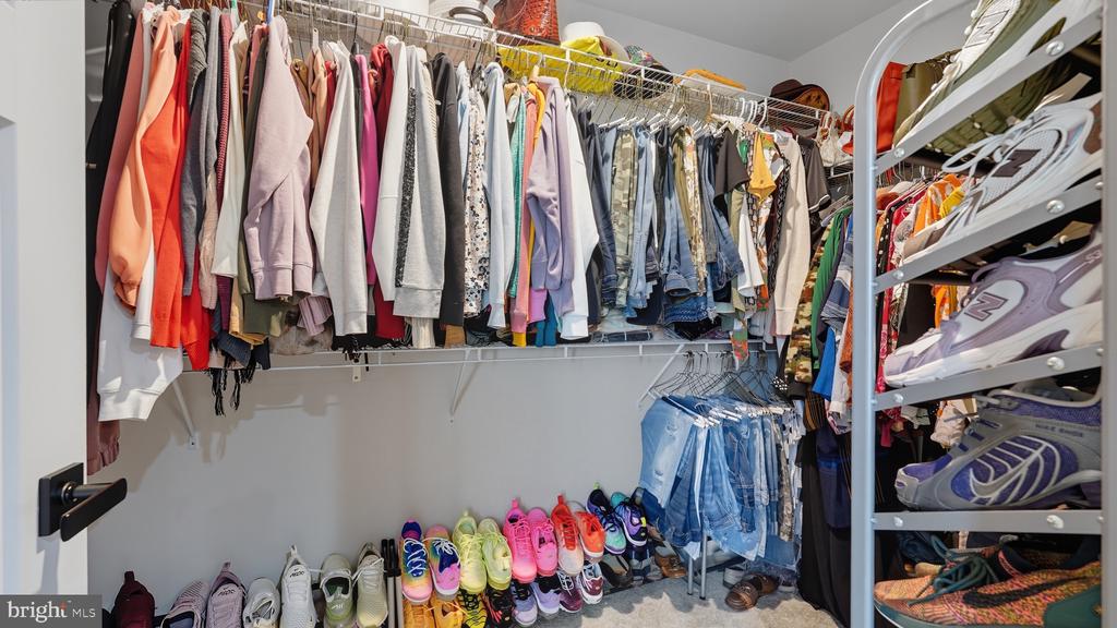 Walk-in closet with extensive clothing racks, shoe storage, and shelves.
