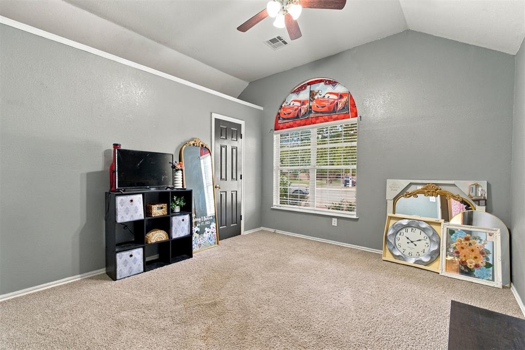 Carpeted gray room with an arched window, ceiling fan, and children's decor.