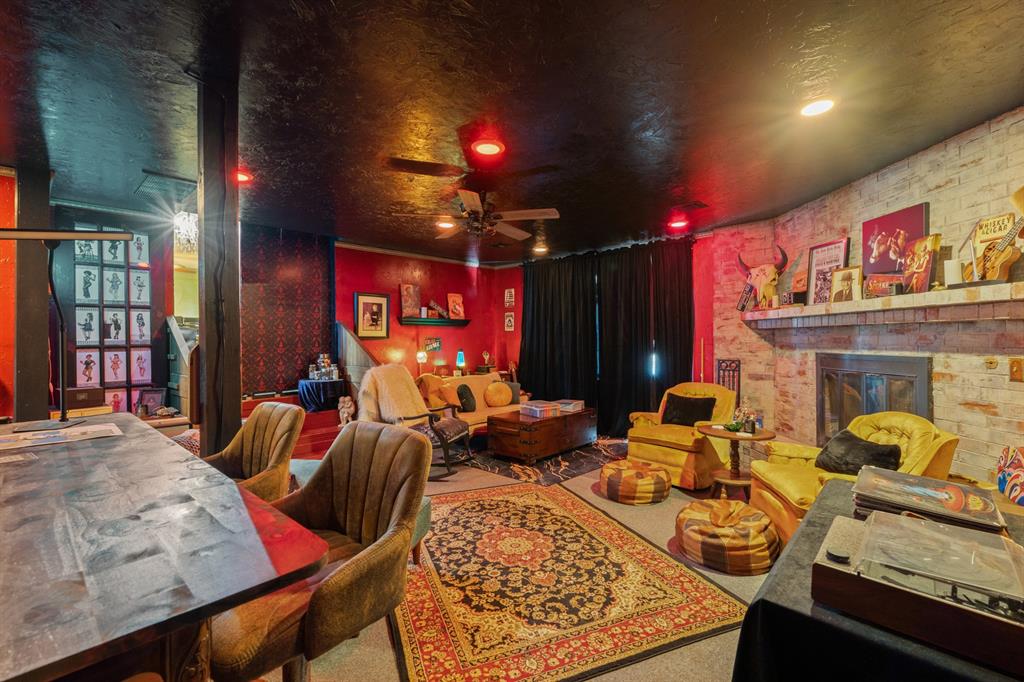 Eclectic living room with yellow leather seating, patterned rugs, and a stone fireplace.