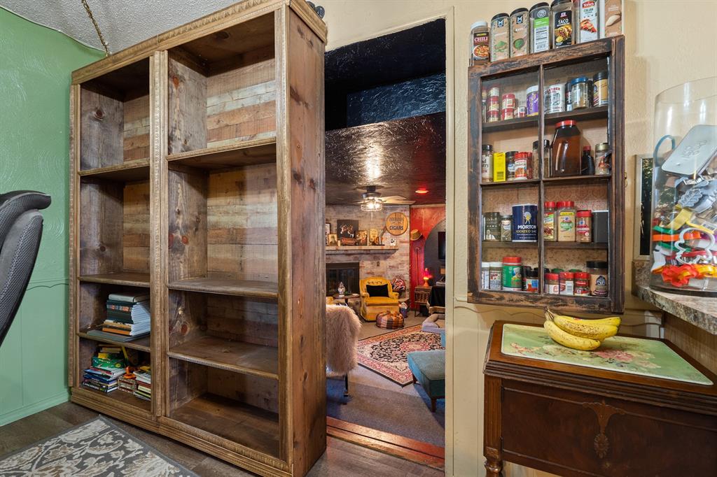 Pantry with rustic built-in wood shelving and a doorway to the living room.