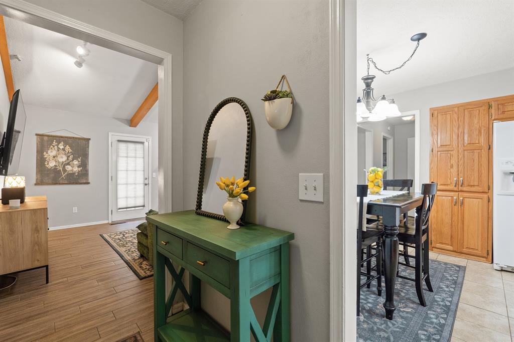 Entryway with a green console table and arched mirror, opening onto living and dining areas.