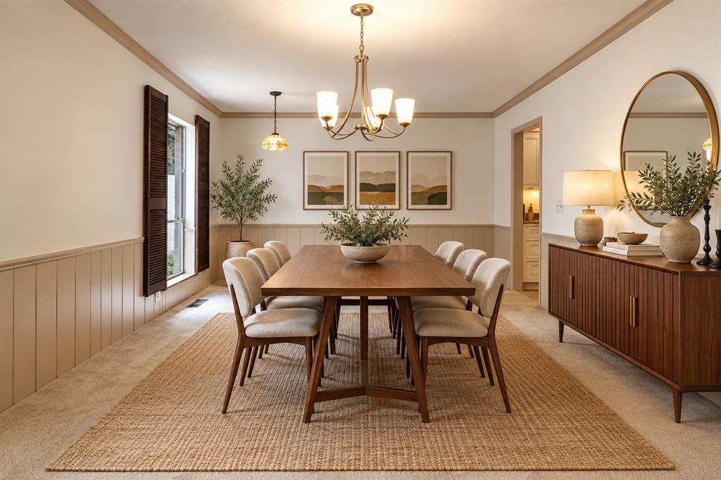 Staged dining room with a wooden table, upholstered chairs, paneled walls, and a brass chandelier.