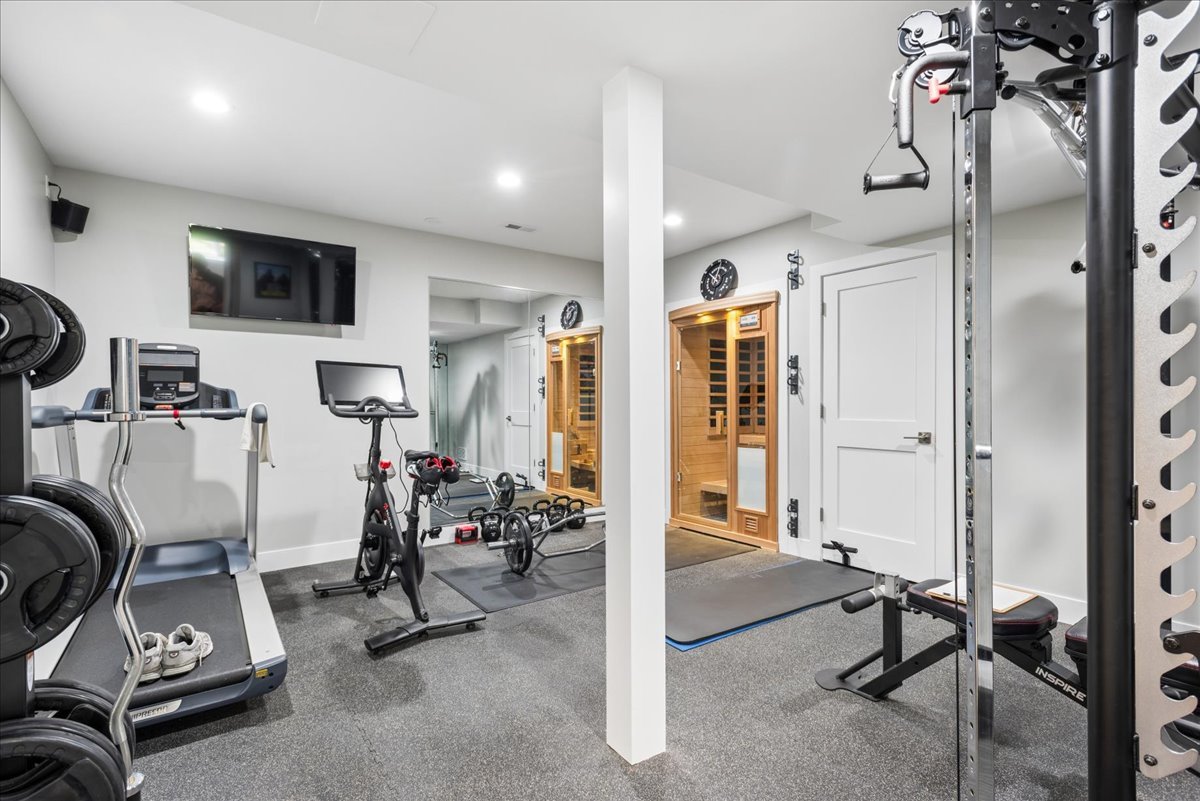 Home gym with treadmills, weight equipment, and two wooden saunas.