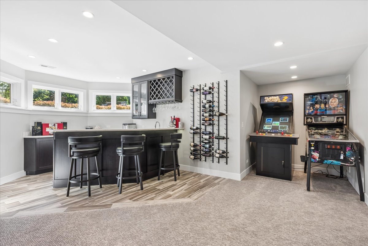 Finished basement bar and game room with wine racks, an arcade cabinet, and a Star Trek pinball machine.