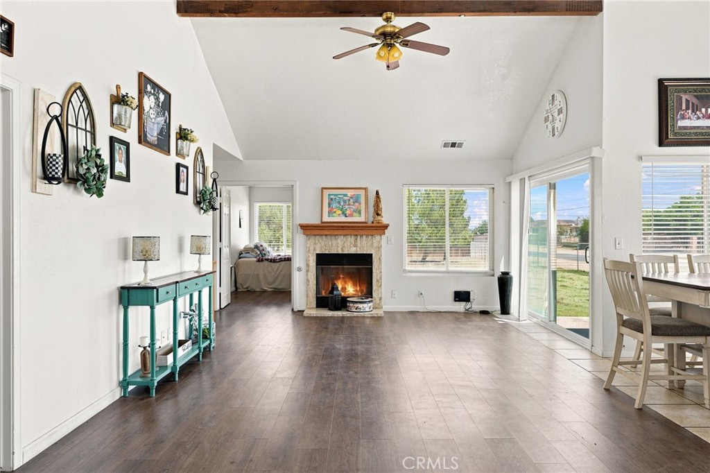 Living room with a fireplace, dark flooring, and sliding glass doors overlooking the yard.